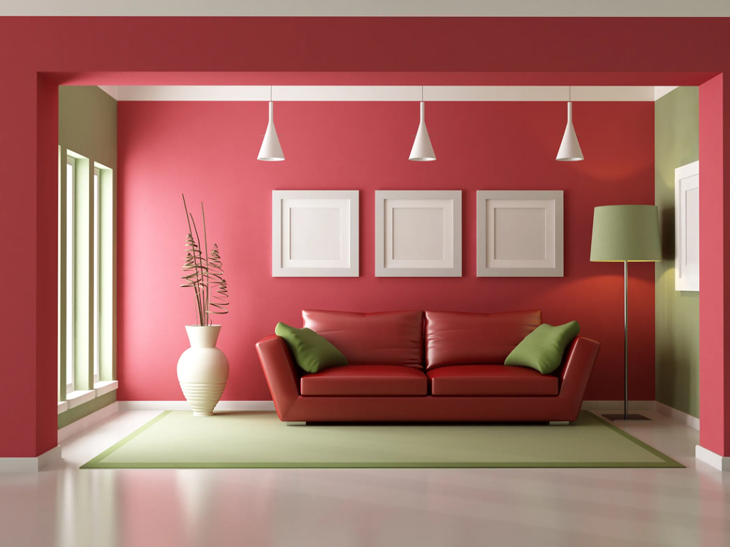 Modern living room with red walls, green accents, a red leather sofa with green cushions, decorative white vase, and stylish lamps, illustrating interior painting and design services by J.A. Painting & Decorations.