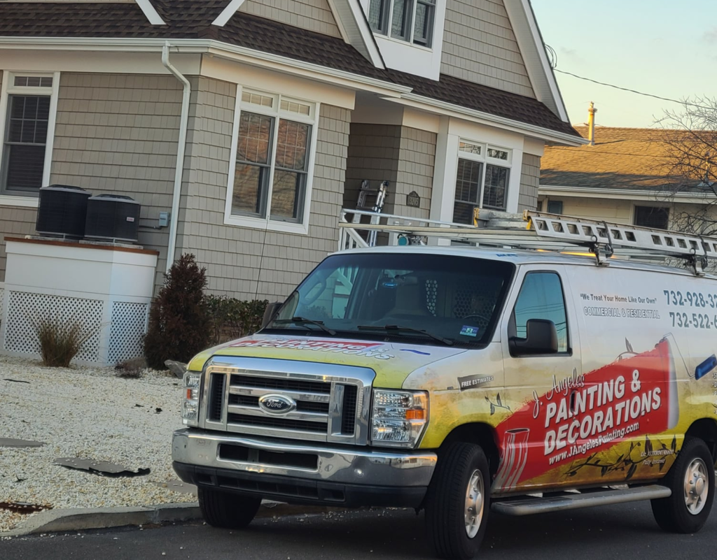 J.A. Painting & Decorations van parked in front of a residential home, showcasing professional painting services with a ladder on the roof and company branding visible.